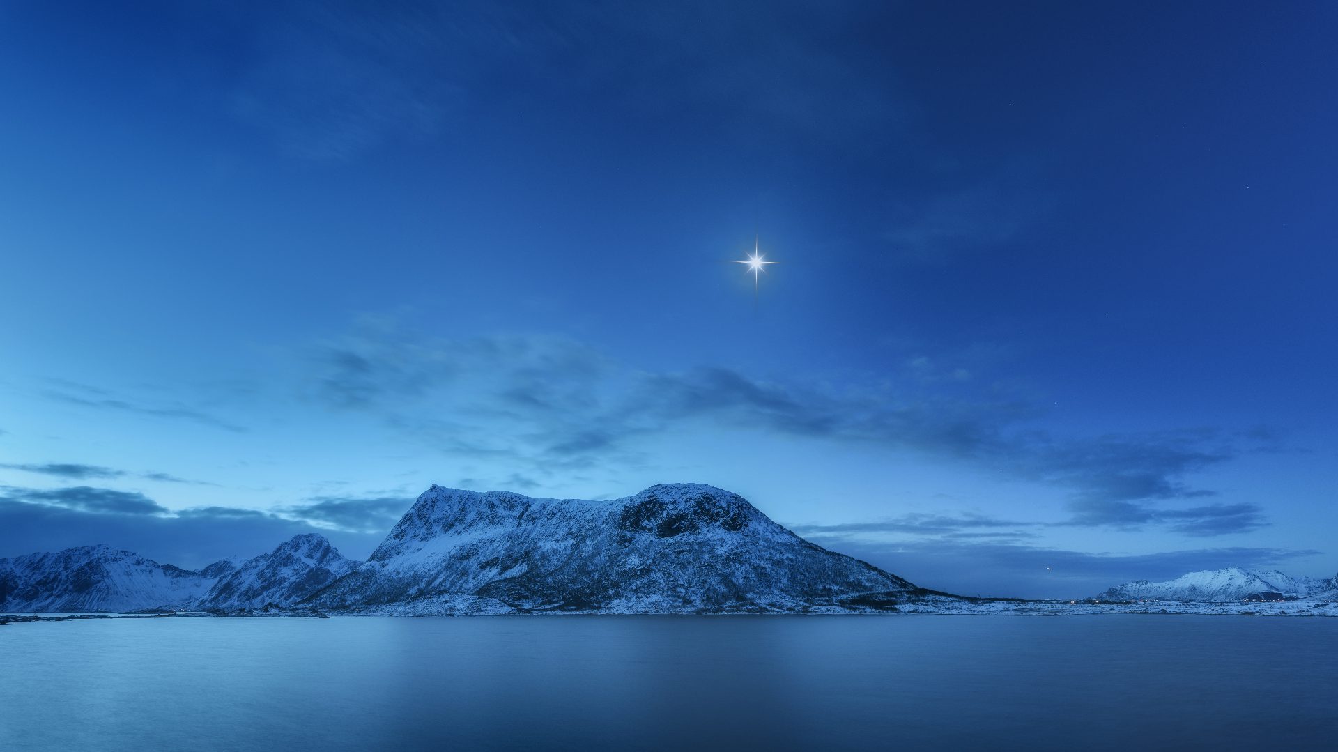 Snow-capped mountains beneath the north star at dusk